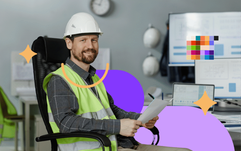 Homem de barba e sorridente vestindo capacete branco e colete refletivo verde de segurança, sentado em uma cadeira de escritório segurando papéis, ilustrando a gestão estratégica da segurança no trabalho.